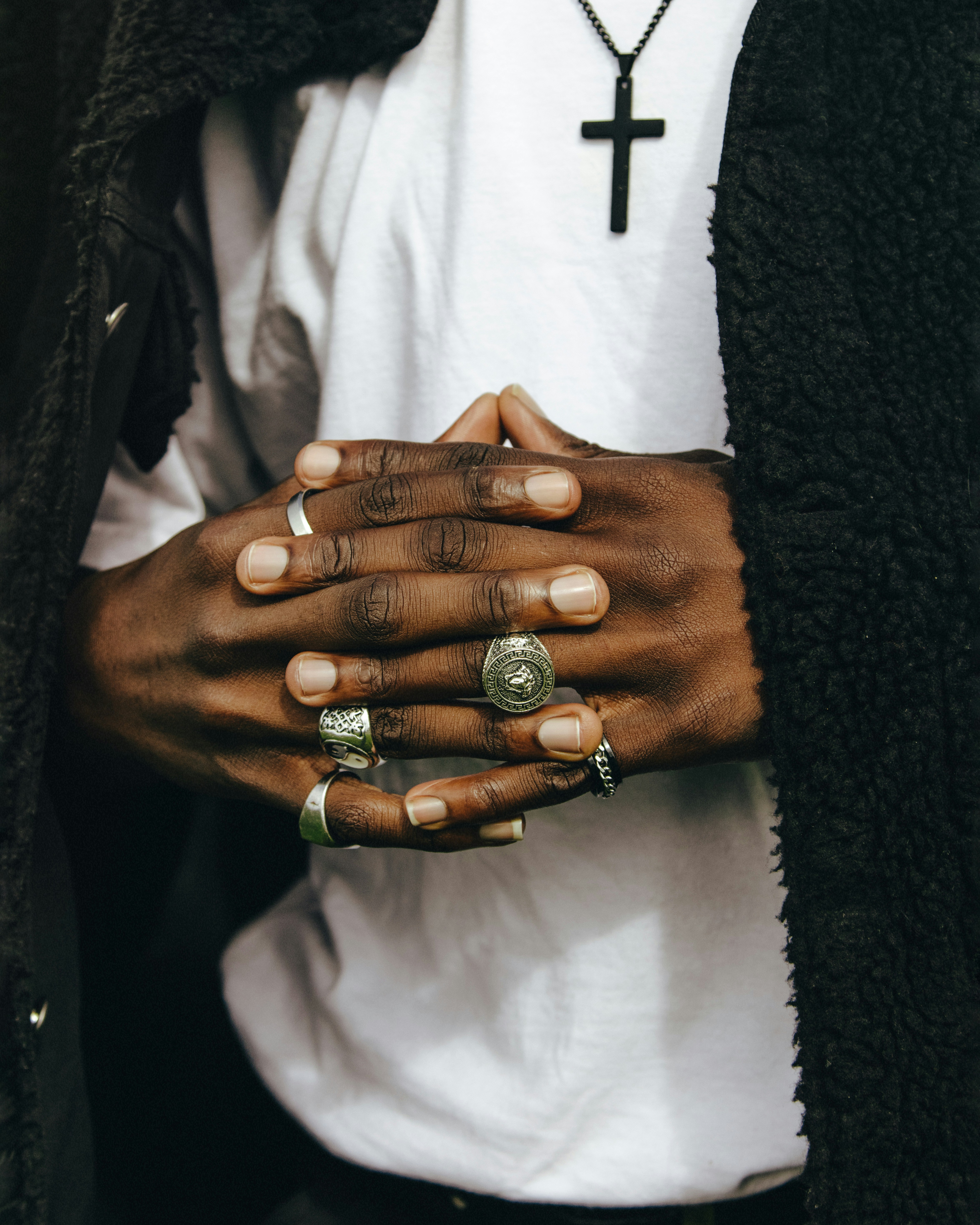 Man with hands together wearing several rings