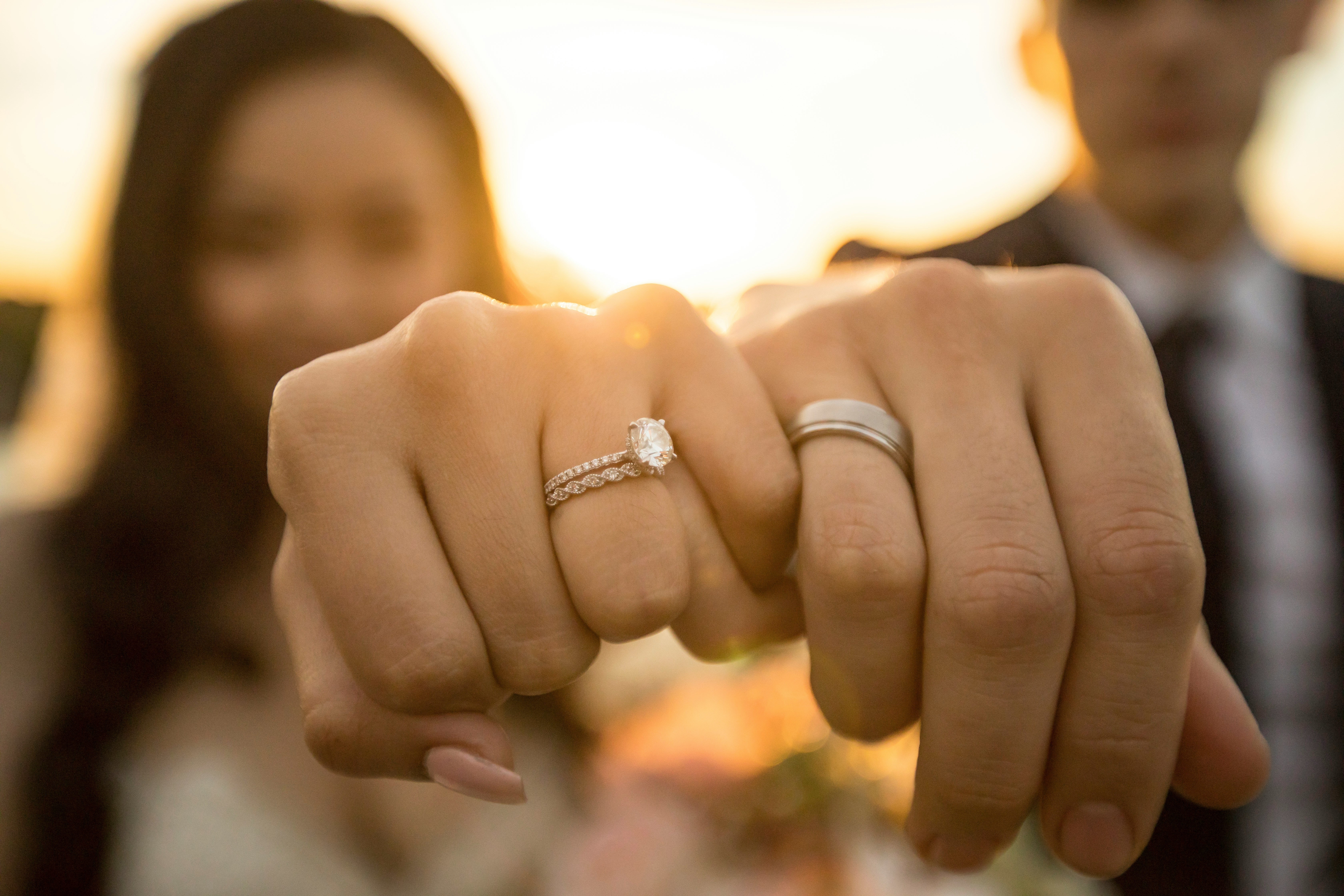 couple hands together in fist wedding rings on, arm outstretched towards the cammera.